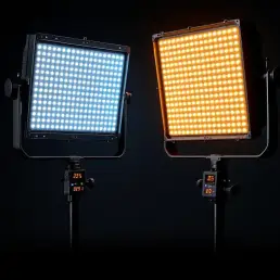 Two professional bi-color LED panels on stands in studio, one emitting warm tungsten light, other cool daylight with power meters