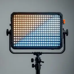Professional bi-color LED lighting panel on black stand showing warm tungsten and cool daylight temperature zones in studio