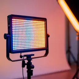 Professional bi-color LED light panel on studio stand creating warm to cool temperature gradient on white backdrop
