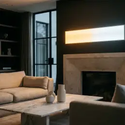 Bi-colour LED panel light casting warm-to-cool gradient over a luxury living room with marble coffee table and linen sofa.