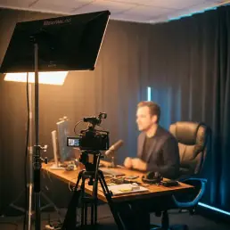 Iluminación LED continua profesional para un estudio de transmisión en directo con cámara, escritorio y posición de presentador.